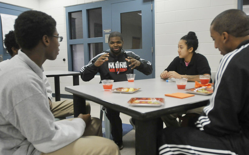 Darren Cooper of the Red Claws shares a story with youth center residents. Listening, from left, are Keelin White, Deeka Loth and Red Claws player JR Reynolds. Long Creek basketball coach Chad Sturgis said the interaction is exciting for his players. “It motivates them,” he said.