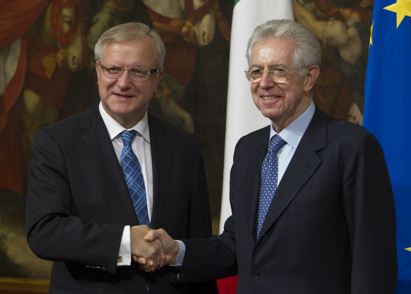 European Commissioner for the Economy Olli Rehn, left, shakes hands with Italian Premier Mario Monti as they meet in Rome on Friday. The Italian government is trying to convince investors that can successfully reduce debt.