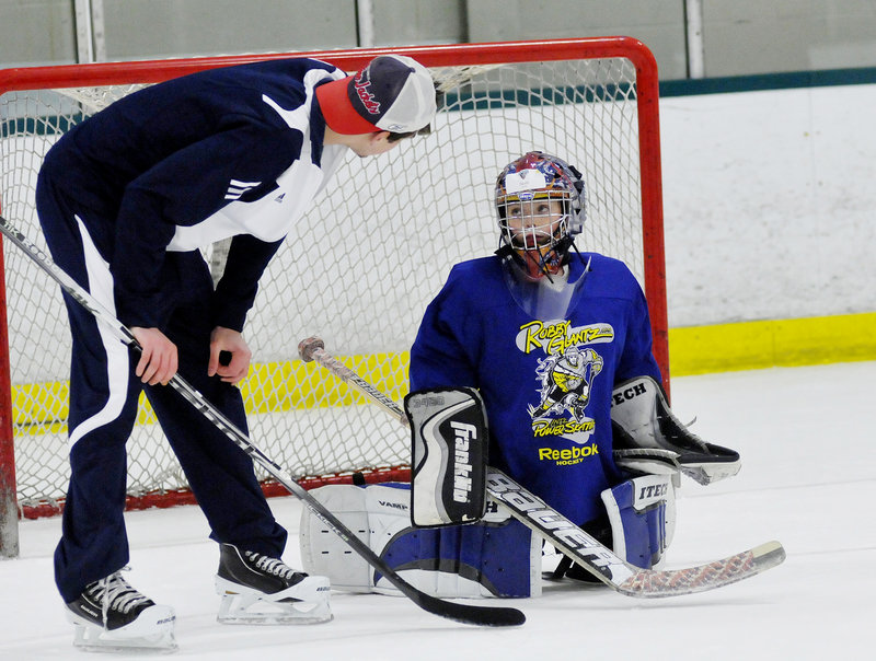 Jacob Veilleux, 9, of Yarmouth receives some goaltending tips from one of the Black Bears' goalies, Martin Ouellette.