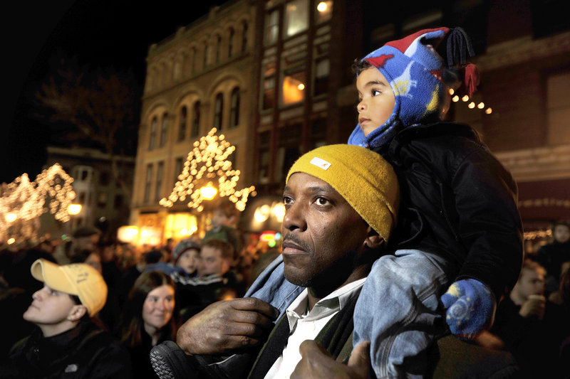 Kazmir Bickens, 2, sits on the shoulders of his dad, Louis, during the tree lighting ceremony.