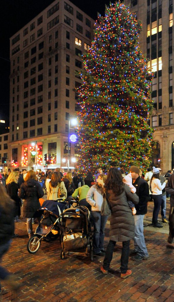 The Christmas tree lights up Monument Square.