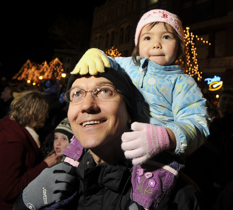 Bob Bukaty of Freeport and his daughter, Bella, watch as the Christmas tree is lit in Monument Square.
