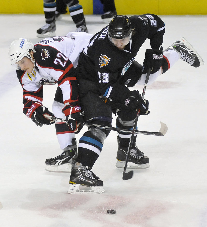 Igor Gongalsky of the Portland Pirates, left, attempts to take the puck from Matt Pelech of the Worcester Sharks. The Pirates won in OT.