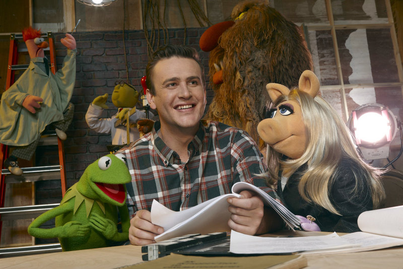 Jason Segel with muppet characters Kermit the Frog and Miss Piggy, in a scene from "The Muppets."