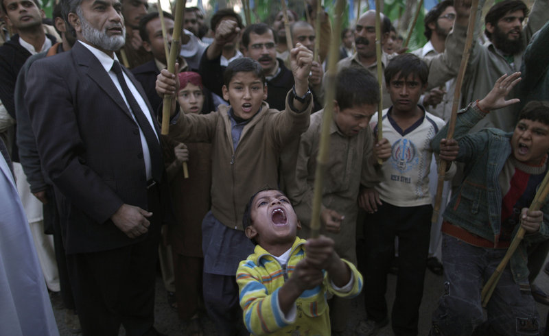 A Pakistani boy, front, shouts slogans along with other protesters during a rally on the outskirts of Islamabad on Sunday to condemn a NATO attack that killed 24 Pakistani troops. The fallen soldiers' funerals were broadcast on television.