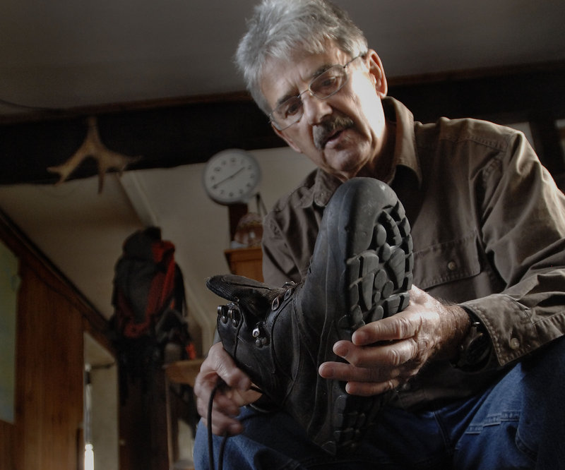 Nelson Daigle talks about the boots he has worn out over the years at his Millinocket home. Daigle has hiked Maine’s tallest mountain more than 400 times over the past 17 years.