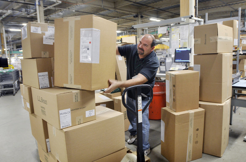 Joe Perron stacks packages to be shipped at an L.L. Bean warehouse in Freeport on Monday. Bean’s biggest sales of the holiday season usually come on Dec. 12, but Cyber Monday also has become an important source of revenue.
