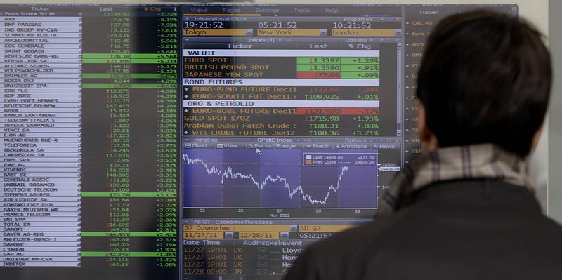A man checks stock indexes on a screen of a bank in Milan, Italy, on Monday. Italy paid sharply higher borrowing rates in an auction Monday, as investors continued to pressure the eurozone's third-largest economy to come up with reforms.