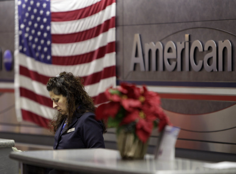 An employee works at an American Airlines counter at LaGuardia Airport in New York on Tuesday. A consultant for the major airlines said, “Labor is going to take a big hit” as the carrier seeks to reduce costs in bankruptcy.