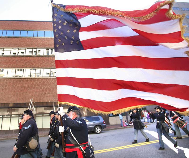 Larry Williams of Harpswell, a member of the 3rd Maine Regiment Volunteer Infantry, carriers an American flag during last year's Veteran's Day Parade down Congress Street in Portland.