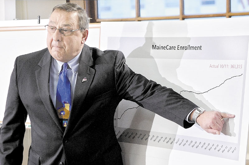 Gov. Paul LePage gestures at a graph to show how much lower he'd like to see MaineCare enrollment numbers drop at a news conference last week in Augusta.