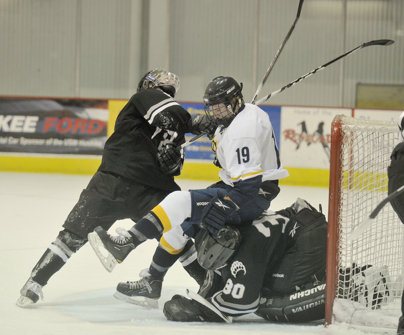 Mike Greene of the University of Southern Maine finds himself sandwiched by Nick Wetzel, left, and Bowdoin goalie Richard Nerland, who covers the puck in the crease Tuesday night during USM’s 3-1 victory. The Huskies have won three straight following a 1-4 start to the season.