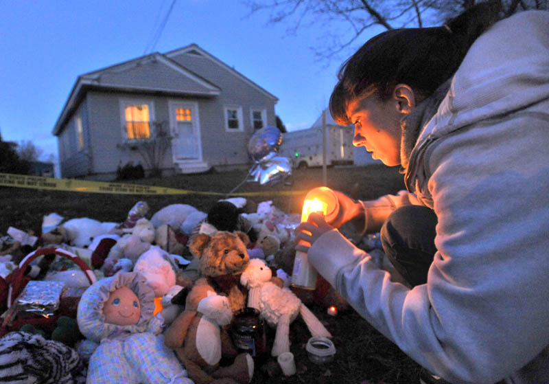 Tara True of Winslow lights candles at the ever growing teddy bear shrine in front of missing 20-month-old Ayla Reynolds' 29 Violette Ave. residence in Waterville Wednesday. Reynolds has been missing for 11 days.