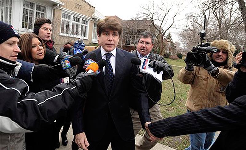 Former Illinois Governor Rod Blagojevich talks with the media while wife Patti leads him away as they leave their home heading to federal court for his sentencing hearing in Chicago, Tuesday, Dec. 6, 2011. Blagojevich was convicted earlier this year on 18 corruption counts, including trying to auction off President Barack Obama's old U.S. Senate seat. (AP Photo/Paul Beaty)