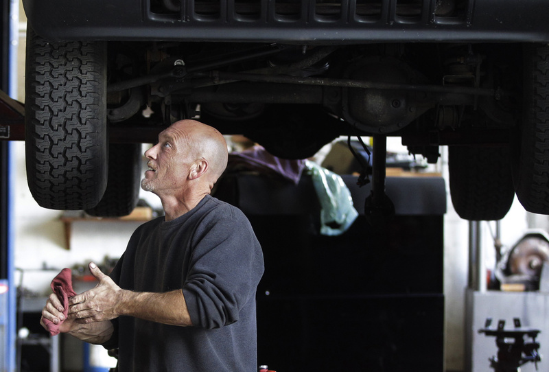 Bruce Worswick wipes his hands while working under a Jeep on the lift at Tri Town Transmission in Pembroke, Mass., on Oct. 4. U.S. service companies, which employ 90 percent of the country's work force, expanded at slower pace in November, and a measure of employment fell sharply.