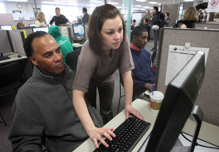 Maria Aplington, from United Parcel Service, helps Craig Wooten navigate their website during a hiring event for UPS at in Portland, Ore. The unemployment rate fell last month to its lowest level in more than two and a half years, as employers stepped up hiring in response to the slowly improving economy.