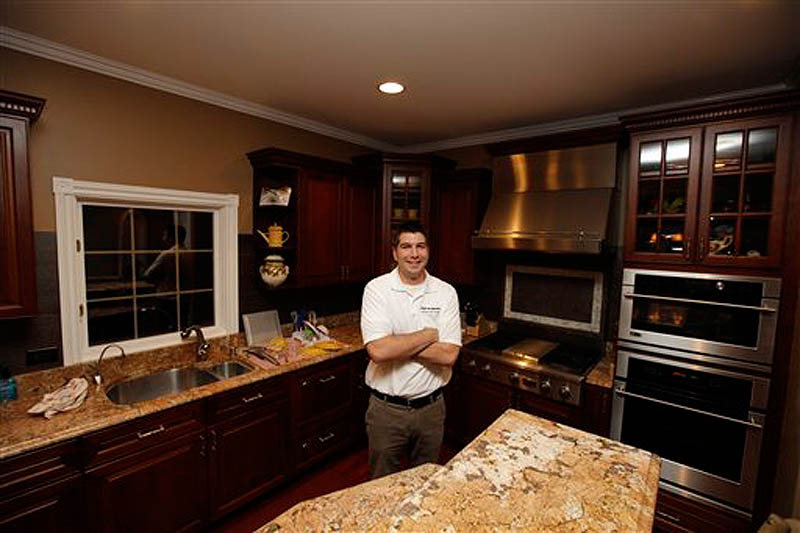 In this Friday, Nov. 18, 2011 photo, David Frank poses as his home in Libertyville, Il. Frank does just about all his own home repairs and remodeling. (AP Photo/Nam Y. Huh)
