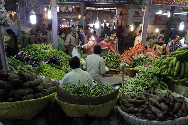 Indians shop for vegetables at a market in Ahmadabad, India, last month. A proposed open-door policy for foreign retailers may be put on hold.