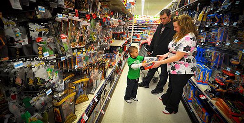 Kevin, center, Jolie, right, and Alex Lewis shop for a family they adopted for Christmas, Thursday Dec 15, 2011 at a Kmart in Omaha, Neb. The Lewises had their layaway paid off at Kmart by an unknown good Samaritan. (AP Photo/Dave Weaver)