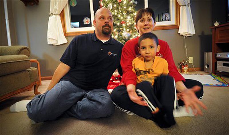 Dona, Matt, left, and Bryce Bremser, sit for photos at their Omaha, Neb. home Thursday Dec 15, 2011. The Bremsers had their layaway at Kmart paid off by an unknown good Samaritan. (AP Photo/Dave Weaver)