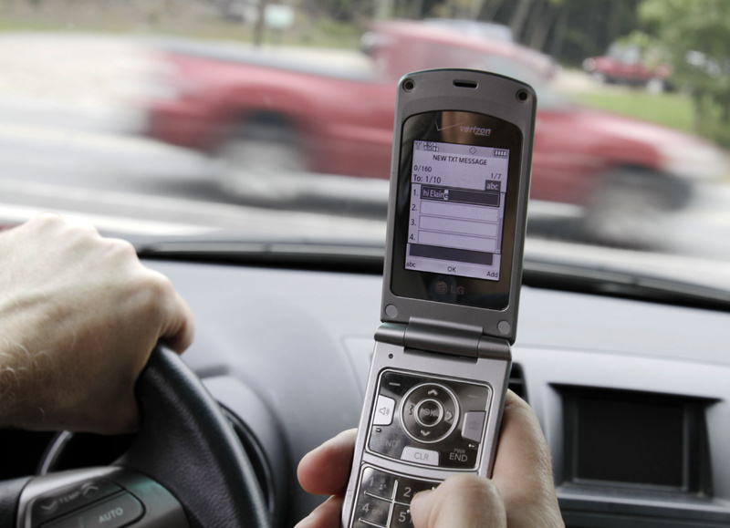 In this Sept. 20, 2011 file photo, a phone is held in a car in Brunswick, Maine. Texting while driving increased 50 percent last year and two out of 10 drivers say they've sent text messages or emails while behind the wheel despite a rush by states to ban the practice, the National Traffic Safety Administration said Thursday. (AP Photo/Pat Wellenbach, File)