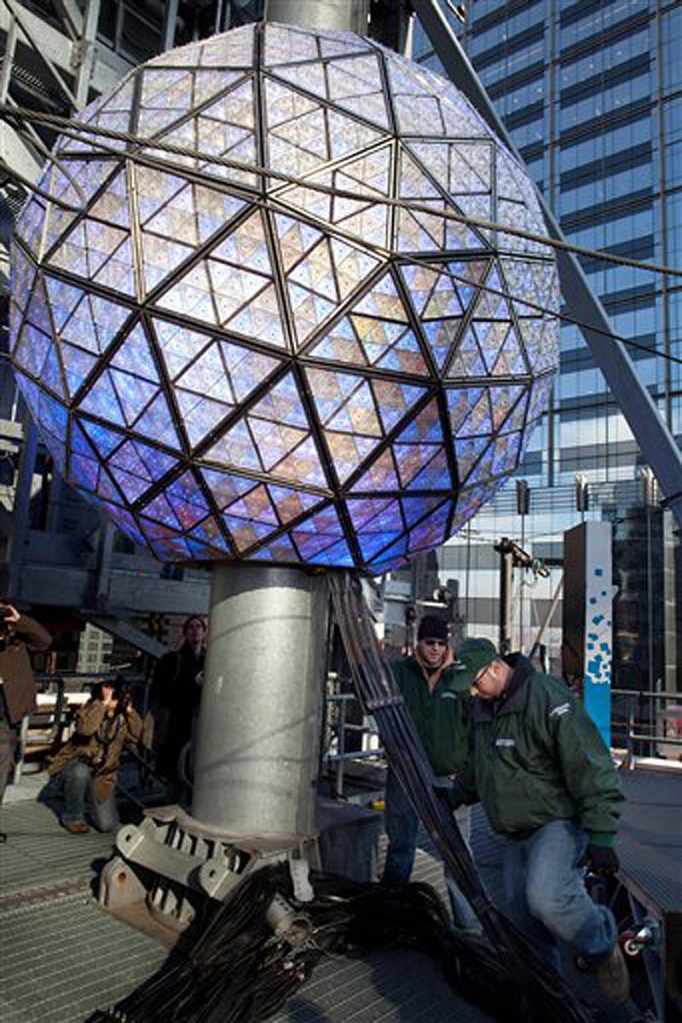 Workers handle the massive cables attached to the Times Square New Year's Eve Ball as it drops from it's perch atop its 135 foot ascension spire, Friday, Dec. 30, 2011, in New York. (AP Photo/John Minchillo)