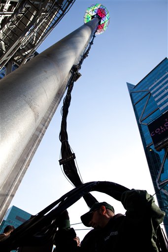 A worker handles the massive cables attached to the Times Square New Year's Eve Ball as it rises to the top of its 135 foot spire, Friday, Dec. 30, 2011, in New York. (AP Photo/John Minchillo)