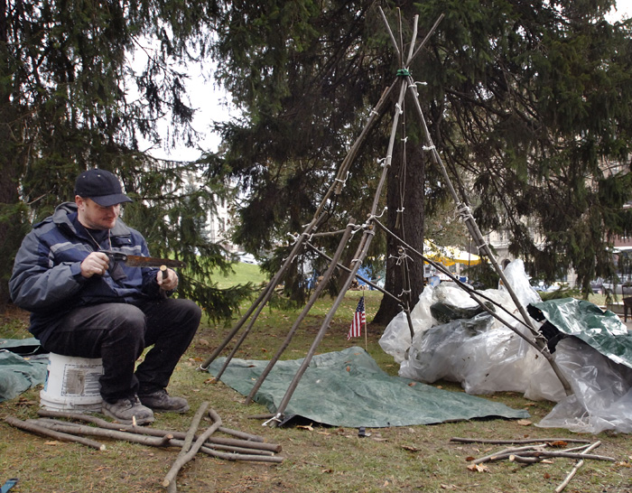 'Aaron' works on making himself a 'teepee' style dwelling at the The Occupy Bangor site in front of Pierce Park and the Bangor Public Library on Harlow Street in this Nov 17, 2011, photo.