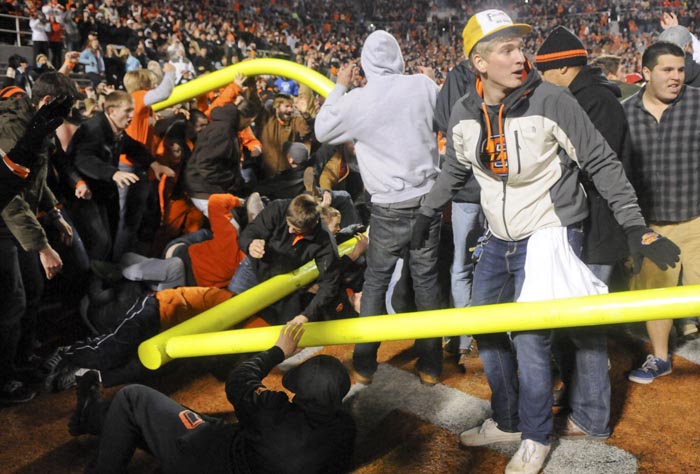 Fans tear down a goal post, injuring some participants, after Oklahoma State's defeat of Oklahoma in Stillwater, Okla.