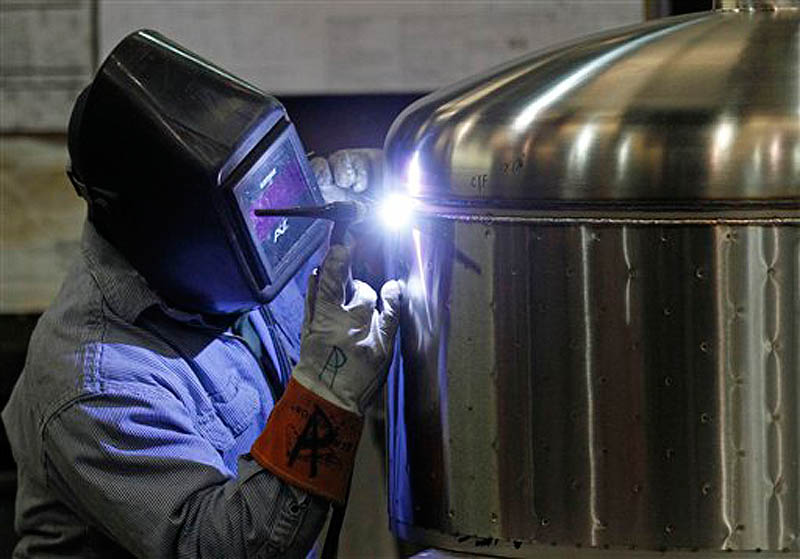 In this Dec. 14, 2011 photo, Kevin Offield makes a weld on a tank at JV Northwest, in Canby, Ore. JV Northwest manufactures stainless steel vessels. The number of people applying for unemployment benefits dropped to its lowest level since April 2008, continuing a downward trend that reflects a strengthening job market. (AP Photo/Rick Bowmer)