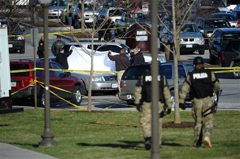 Police officials examine the body of a police officer shot to death in a parking lot on the campus of Virginia Tech, Thursday, Dec. 8, 2011, in Blacksburg, Va. A gunman killed a Virginia Tech police officer Thursday at a campus parking lot and then apparently shot himself to death nearby in a baffling attack that shook up the school nearly five years after it was the scene of the deadliest shooting rampage in modern U.S. history. (AP Photo/Don Petersen)