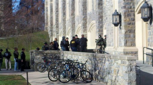 In this image taken on a cell phone, authorities gather outside Torgersen Hall on the Virginia Tech campus in Blacksburg, Va., Thursday, Dec. 8, 2011. A gunman killed a police officer and another person after a traffic stop on the campus Thursday. The school said a police officer pulled someone over for a traffic stop and was shot and killed. The shooter ran toward a nearby parking lot, where a second person was found dead. (AP Photo/The Roanoke Times, Jeff Sturgeon)