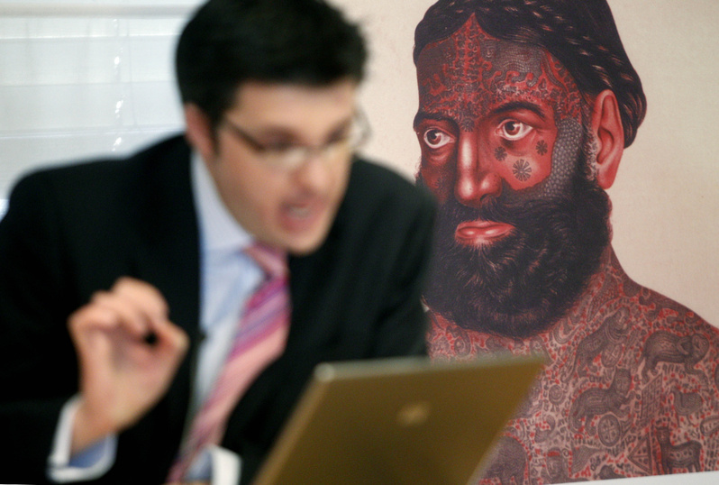 William Purkis, left, of the University of Birmingham discusses tattoos with a picture of a highly tattooed mystic.