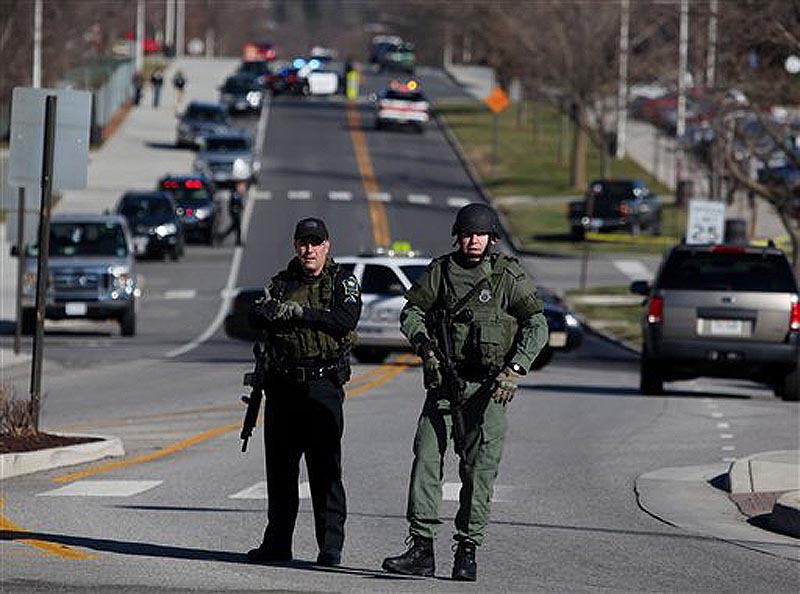 Police officers block a road on the Virginia Tech campus in Blacksburg, Va., after a gunman killed a police officer and another person Thursday, Dec. 8, 2011. The school said a police officer pulled someone over for a traffic stop and was shot and killed. The shooter ran toward a nearby parking lot, where a second person was found dead. (AP Photo/The Roanoke Times, Matt Gentry)