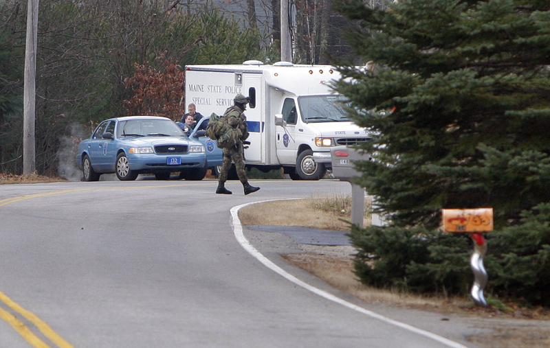A SWAT team member walks across New Dam Road in Sanford this morning. Police are searching for fugitive David Hobson.