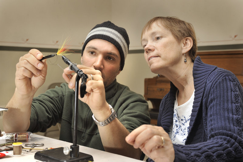 Greg Bostater, a Maine guide and class organizer, helps to assemble a Mickey Finn during a recent fly tying class. “Nothing is quite like being in a class and getting that sense of community,” he says.