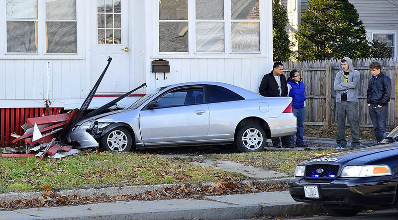 No one was hurt Wednesday morning when this Honda Civic driven by a student at Southern Maine Community College crashed into the stairs of a house at 964 Forest Ave., Portland. Konstantin Bochkarev, second from right, said he was going to school when he hit the gas instead of the brake.