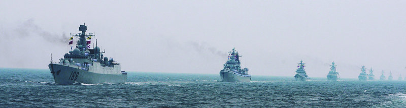 Chinese Navy warships sail during an international fleet review off Qingdao, in China’s Shandong Province. Both China and India are investing heavily in military hardware.