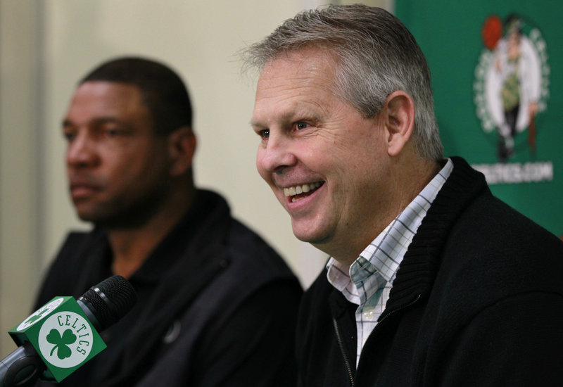 Danny Ainge, foreground, the president of basketball operations for the Boston Celtics, has only six signed players and basically has to fill an entire bench for Coach Doc Rivers, rear, as training camp and the regular season approaches.