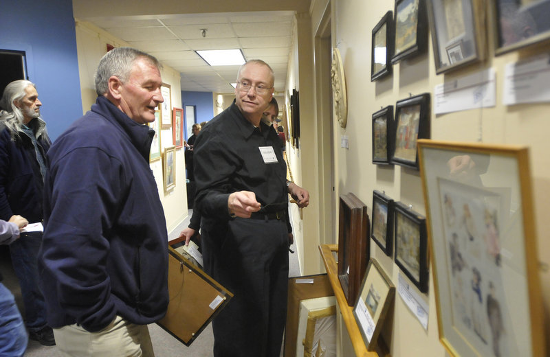 Bob Parker, of Goodwill Industries of Northern New England, talks with Pete Cloutier, left, of South Portland, about the art for sale during Goodwill’s sixth biannual “Art for Everyone: A Collection of Donated Art” on Friday.