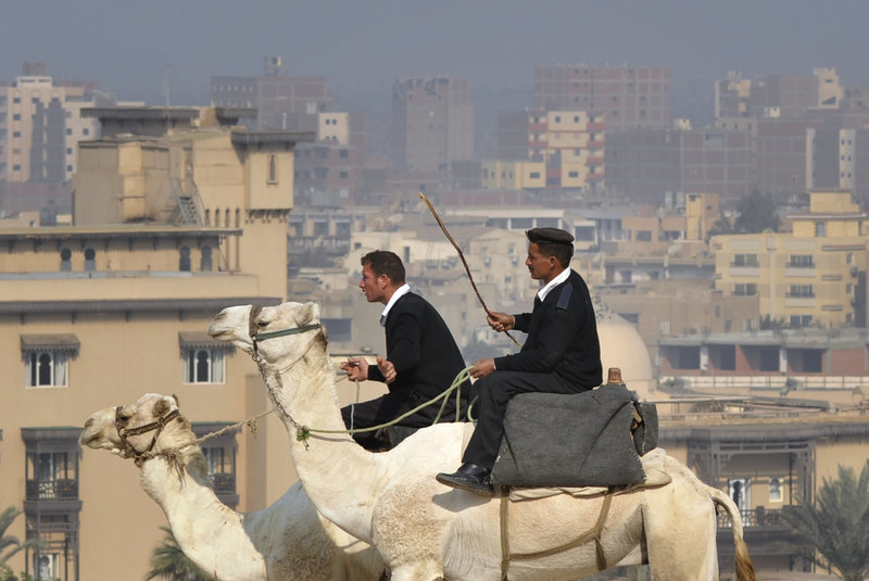 Egyptian policemen patrol on camels close to the Giza Pyramids near Cairo, Egypt, on Saturday. The vote for parliament’s lower house is taking place over three stages, with 18 provinces in Egypt yet to vote.