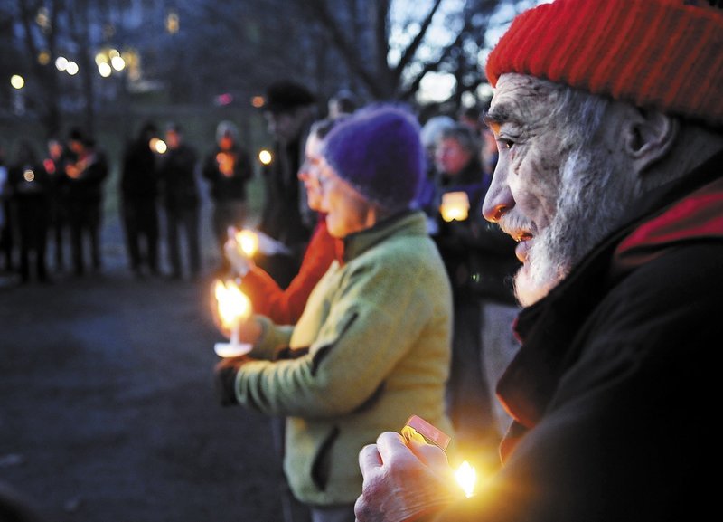 Charles Acker of Whitefield holds a candle Sunday during a vigil with members of several local church congregations to show solidarity with the Occupy Augusta members at Capitol Park in Augusta.