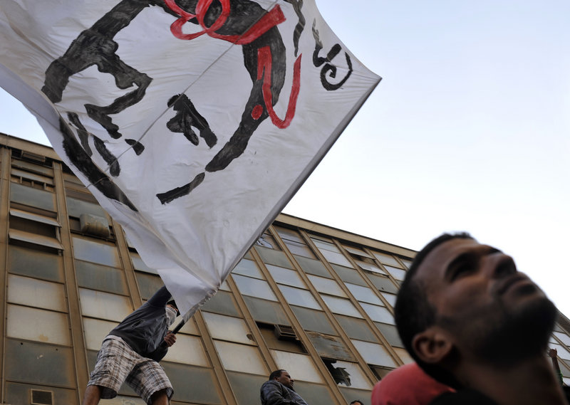 A protester waves a flag depicting Khaled Said, whose death at the hands of police in the city of Alexandria helped spark the uprising that ousted President Hosni Mubarak, at a rally in Cairo on Friday against Egypt's ruling military.