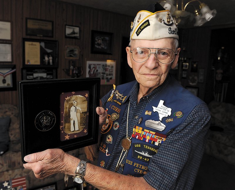 Pearl Harbor veteran Frank Curre holds a photograph of himself as a young Navy sailor in this June 23, 2011, file photo in Waco, Texas. Curre died Wednesday, exactly 70 years after surviving the surprise Japanese attack on Pearl Harbor. The Waco native was 88 years old.