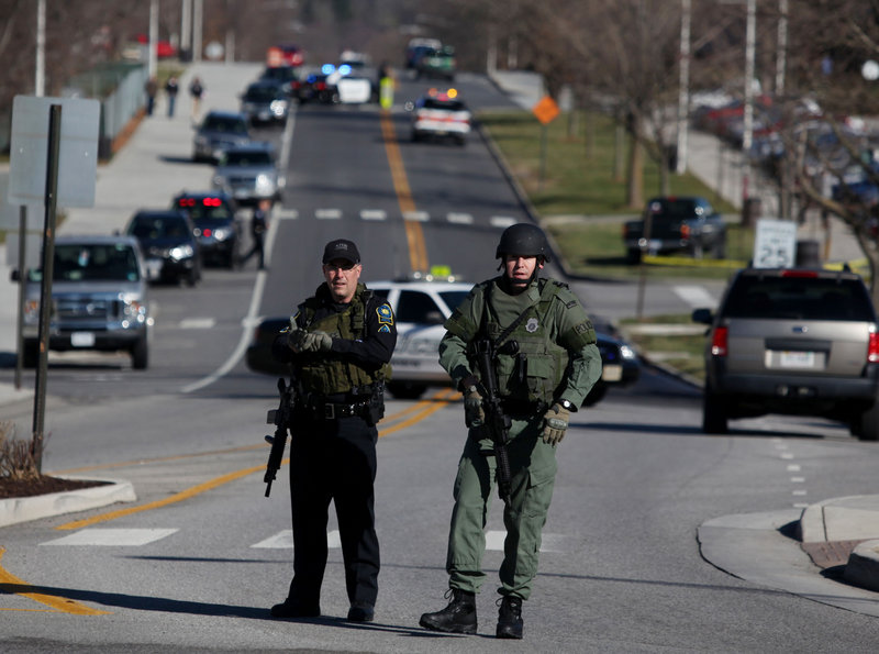 Police officers block a road on the Virginia Tech campus in Blacksburg, Va., after a gunman killed a police officer Thursday. The school said the officer pulled someone over for a traffic stop and was shot and killed.