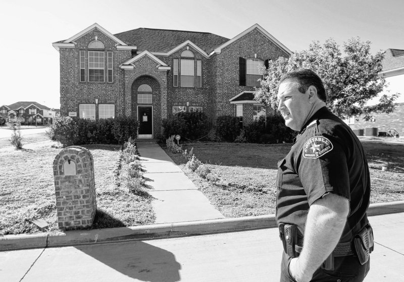 Constable Clint Burgess checks a house where squatters were evicted in Mansfield, Texas, late last month. Properties vulnerable to squatters include those whose owners died.