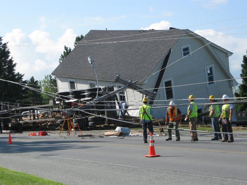 Officials survey the scene of a logging truck accident in July. The truck crashed near a Jackman home, sending logs rolling into the house and killing a 5-year-old boy. The truck driver, Christian Cloutier, will not be prosecuted, the Somerset County District Attorney’s Office has decided.