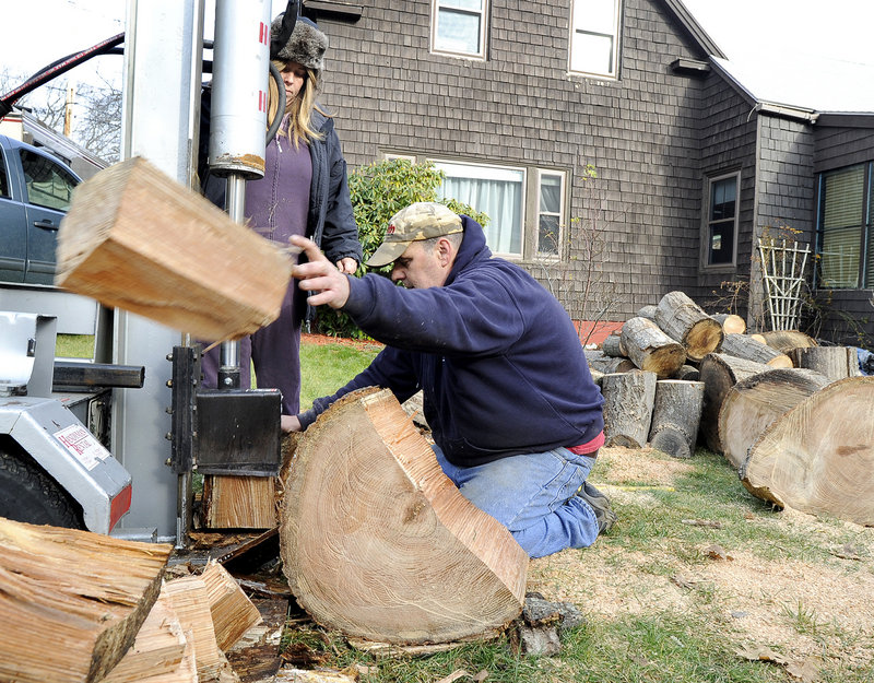 Kristen and Eric Flink split large pieces of red oak for firewood that their mother can use for the winter on Preble Street in South Portland on Friday.