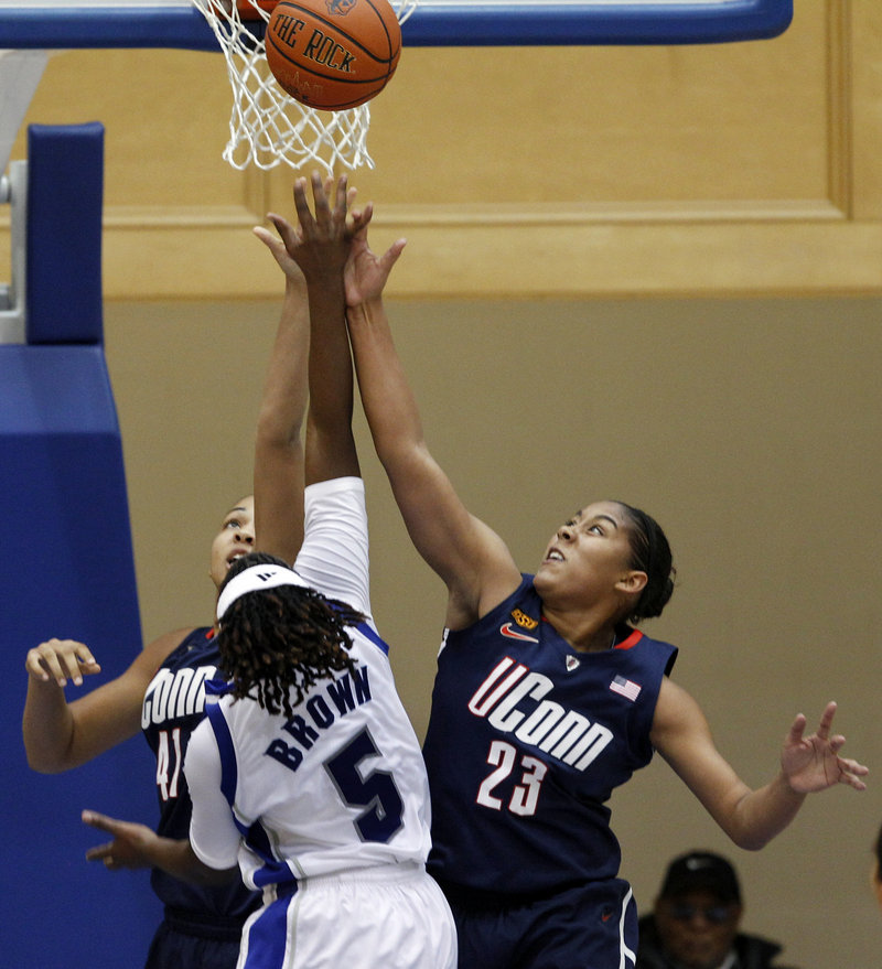 Kiah Stokes, left, and Kaleena Mosqueda-Lewis team up to block a shot by Seton Hall’s Alexis Brown during Connecticut’s 70-37 win Friday night.