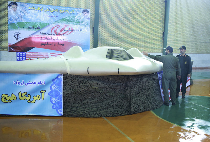 This photo, released Thursday by the Iranian Revolutionary Guards, claims to show the U.S. drone that Tehran says it downed last week. Gen. Amir Ali Hajizadeh, right, chief of the Guards’ aerospace division, listens to an unidentified colonel.